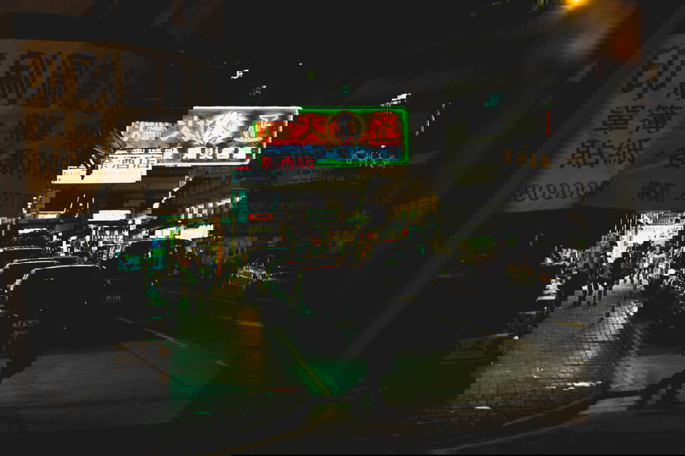 Looking down a street in Hong Kong at night with neon signs