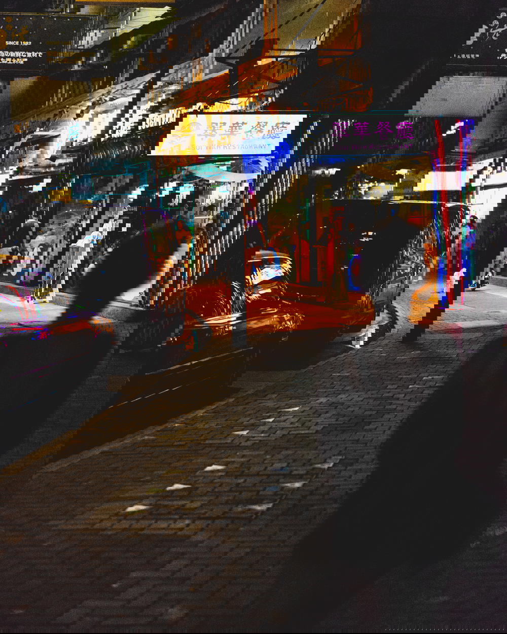 Girl silhouetted by neon signs at night