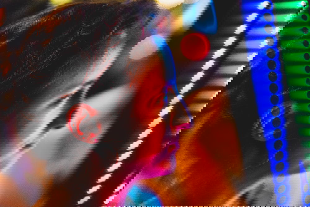 A woman in Hong Kong staring at a vibrant arcade machine.