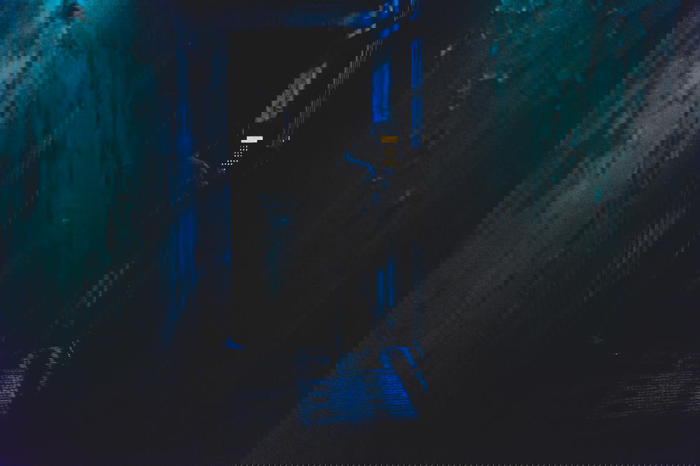 Dark narrow street alley at night showing a door entrance