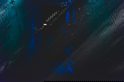A person standing in a dark hallway at night in Hong Kong.