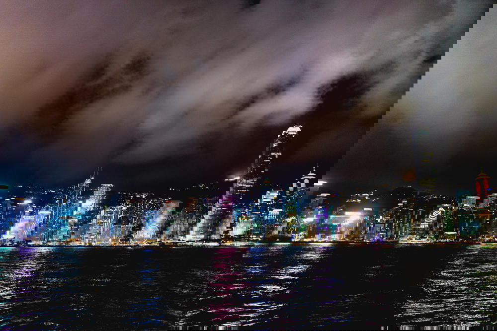 View of the colorful Hong Kong skyline at night with dark clouds