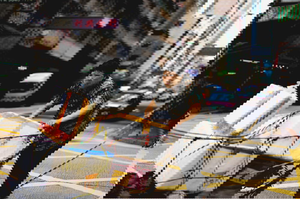 Woman pushing a cart of bins down the street