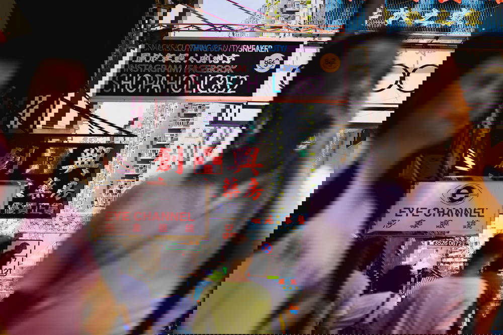 A group of people walking down a street in Hong Kong.