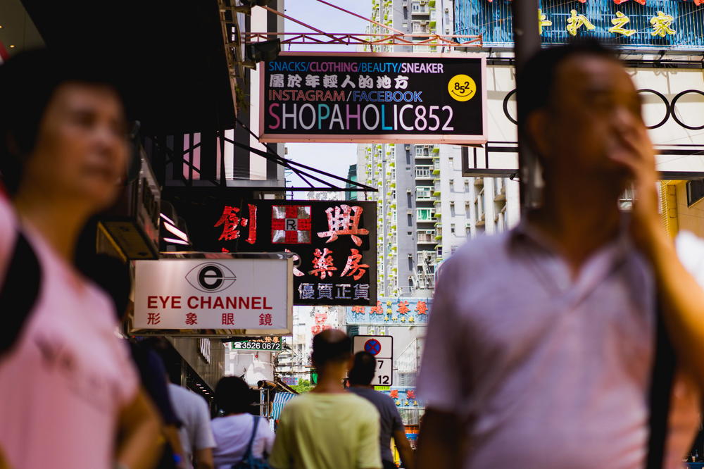 A group of people walking down a street in Hong Kong.