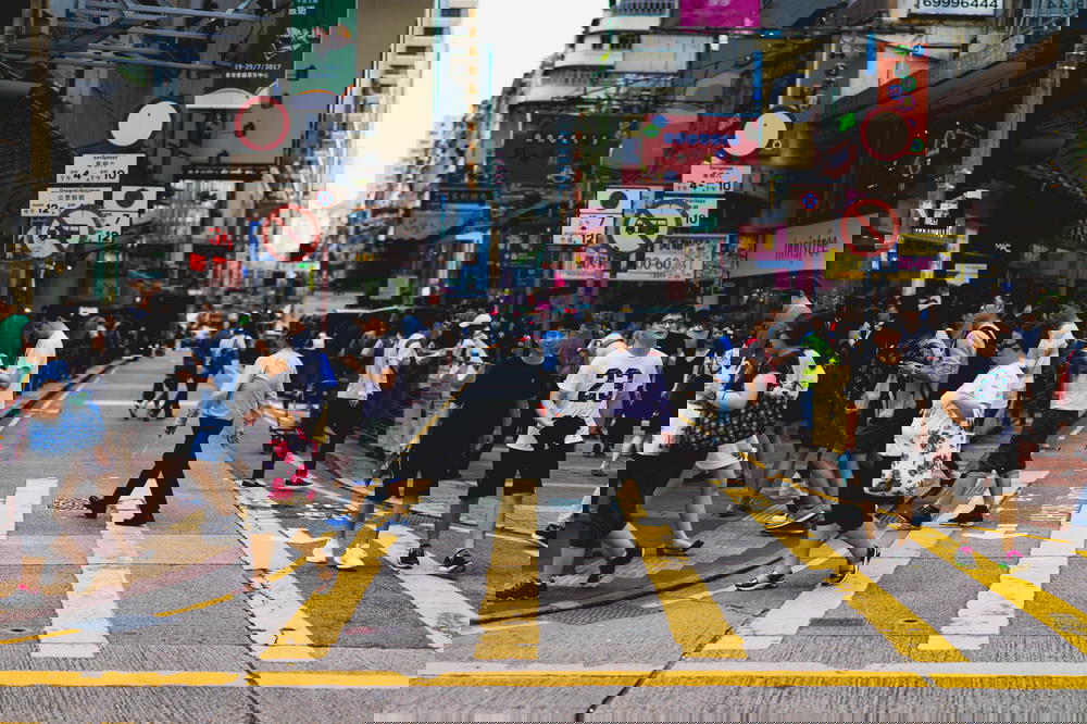People walking through a cross-walk in Hong Kong