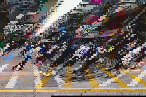 A crowd of people crossing a street in Hong Kong.