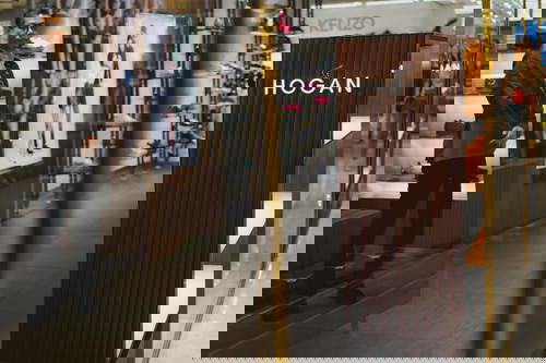 A man standing in front of a Hogan store in Hong Kong.