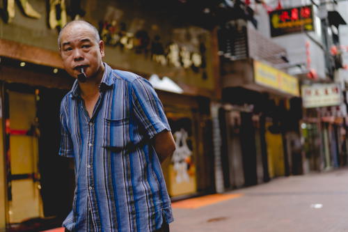 A man with a cigarette in his mouth in Hong Kong.
