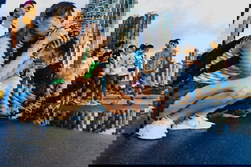 A group of people from Hong Kong taking pictures in a puddle.