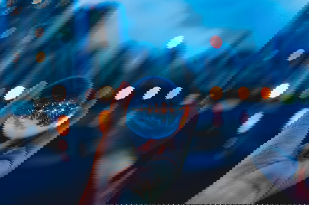 Reflection of skyscrapers and city lights in a glass sphere