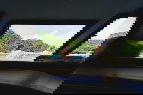 Two people peering out of a boat window in Hong Kong.