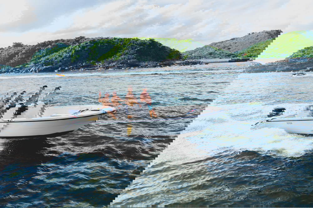 Guys waving from a small boat