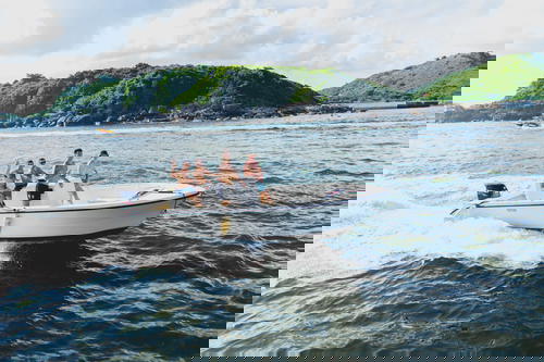 A group of people riding a small motor boat in Hong Kong.