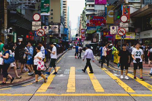 A crowd of people crossing a Hong Kong street.