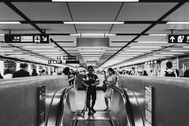 A black and white photo of people on an escalator in Hong Kong.