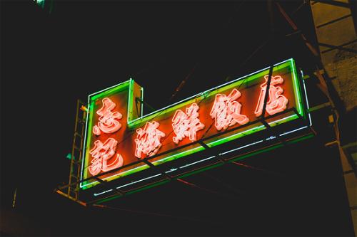 A neon sign on the side of a Hong Kong building.
