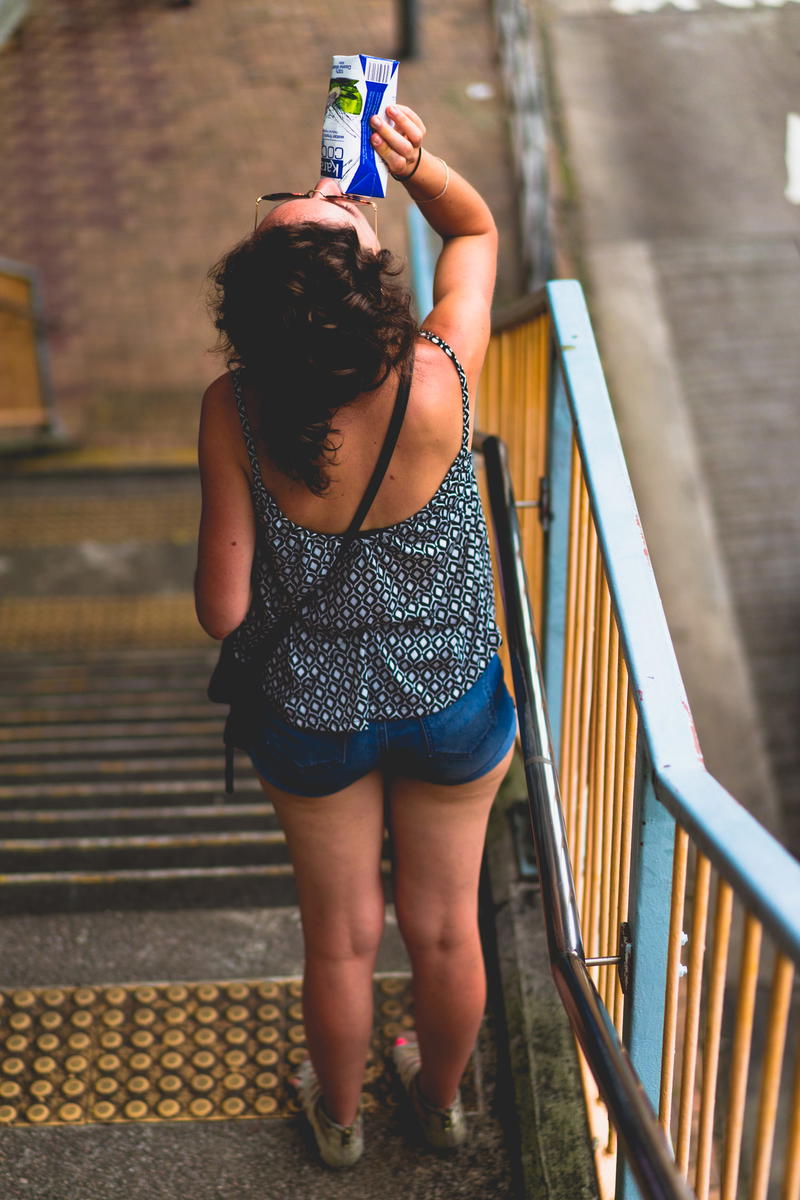 A woman photographing a bottle of water in Hong Kong.