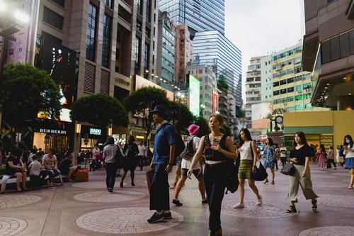 A group of people walking down a Hong Kong city street.