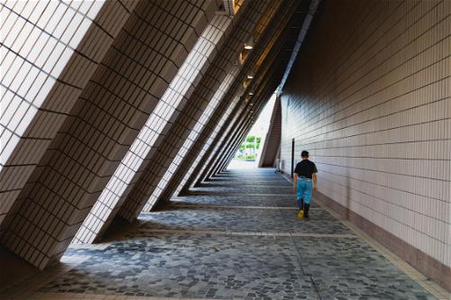 A person is walking down a hallway in a Hong Kong building.