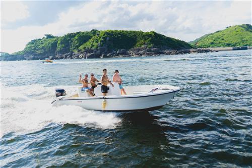 A group of people riding a small motor boat in the ocean near Hong Kong.