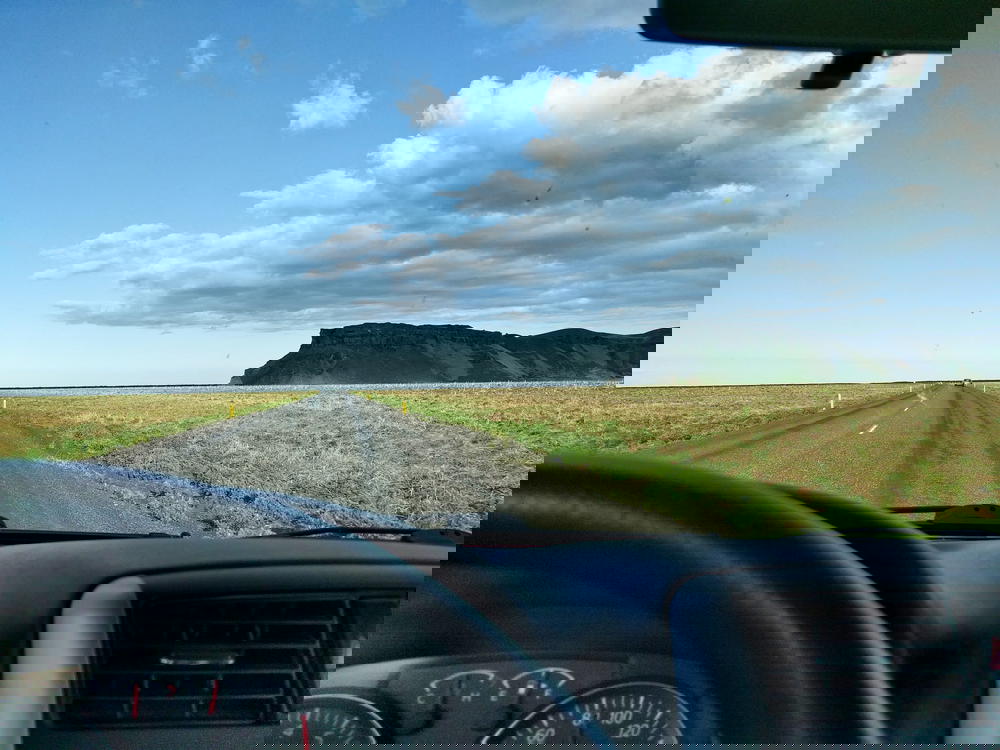 The view from the driver's seat of a car on a highway in Iceland.