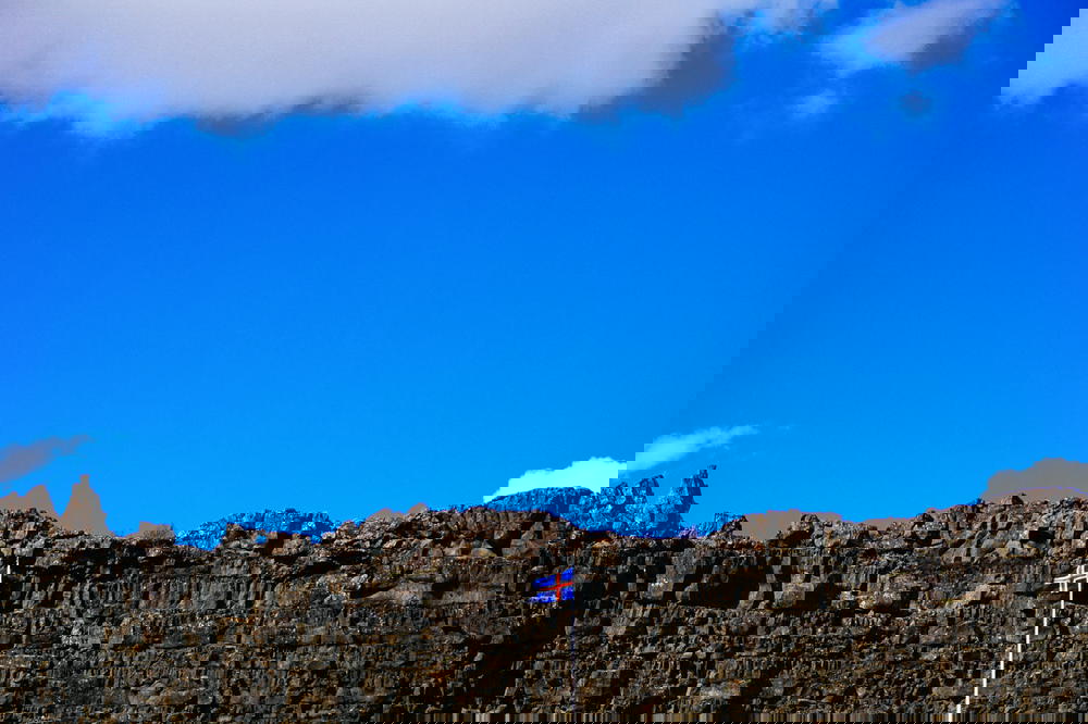 Icelandic flag against a stone wall in Thingvellir National Park