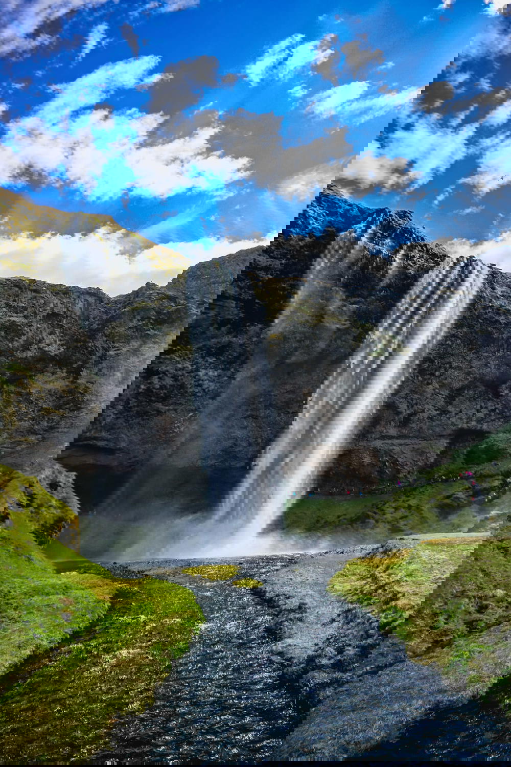 A waterfall in Iceland with a blue sky.