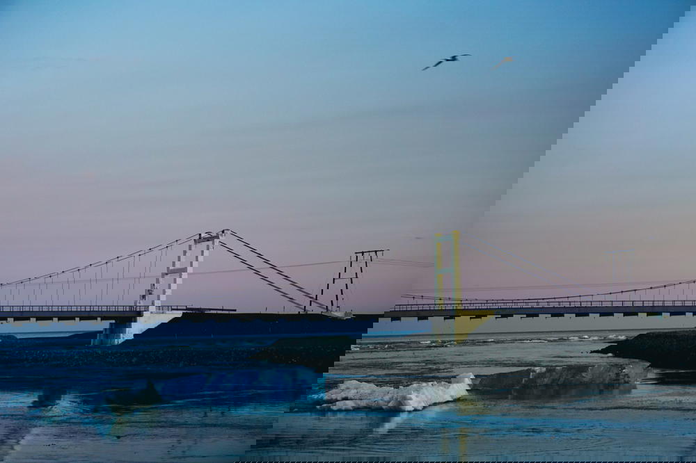 A bridge connecting Iceland to icebergs over a body of water.