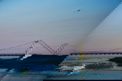 A bridge connecting Iceland to icebergs over a body of water.