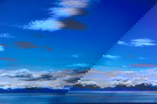 A blue sky with clouds over a body of water in Iceland.