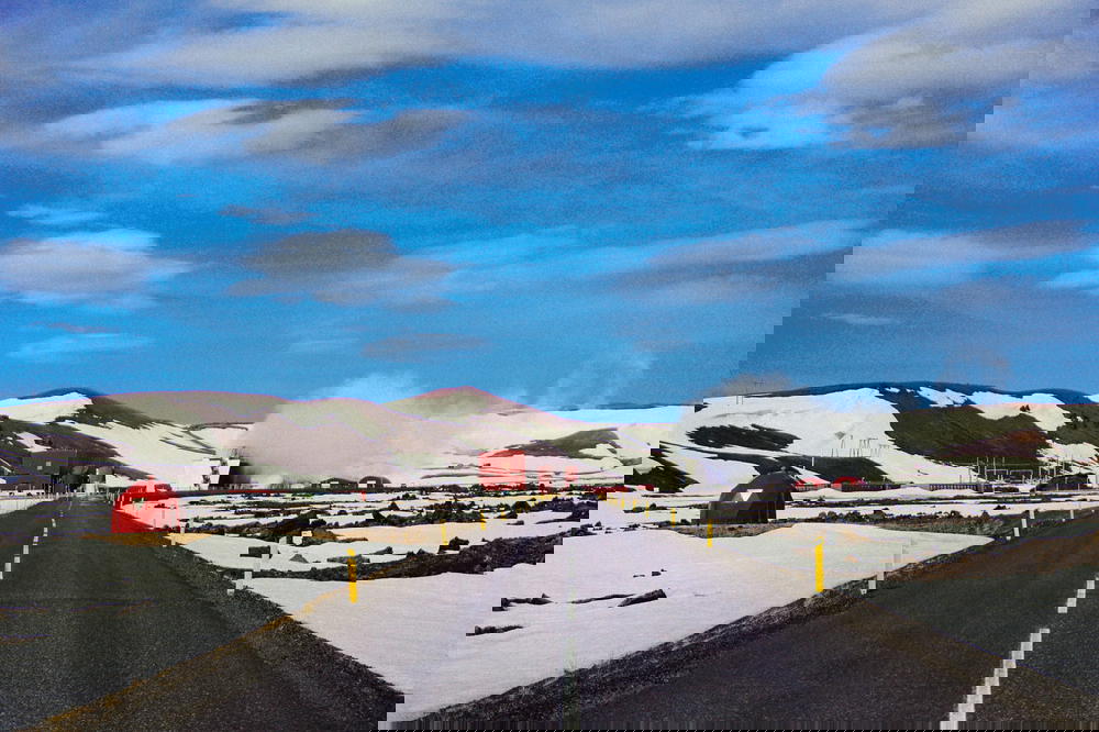 A road in the middle of a snowy Icelandic landscape.