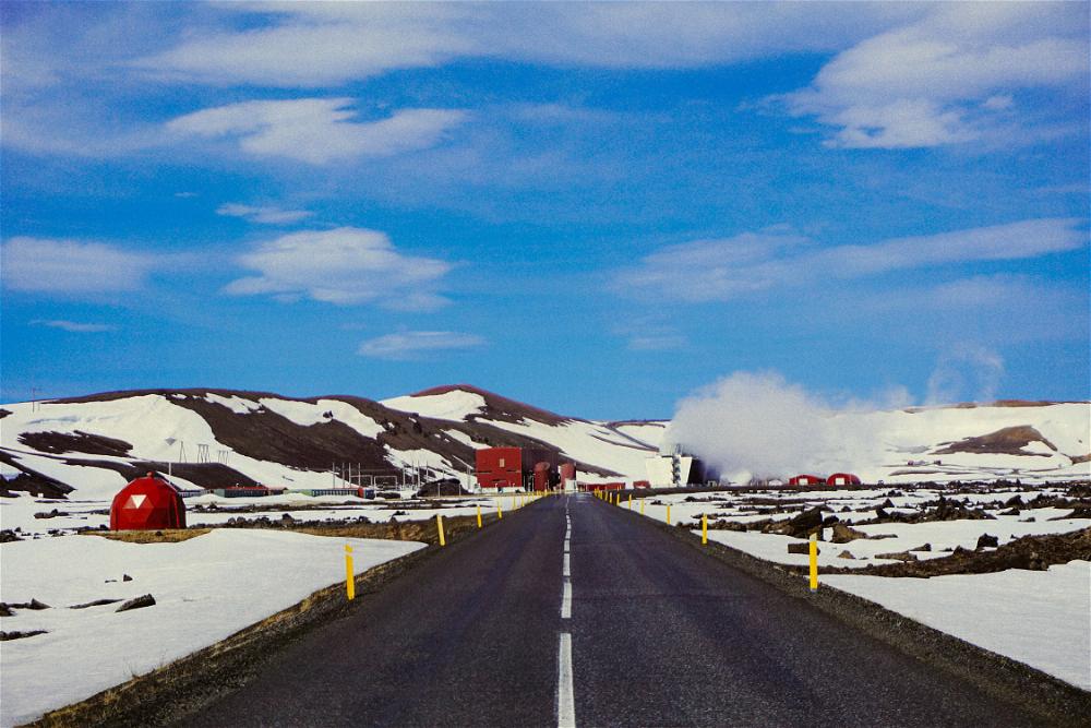 A road in the middle of a snowy Icelandic landscape.