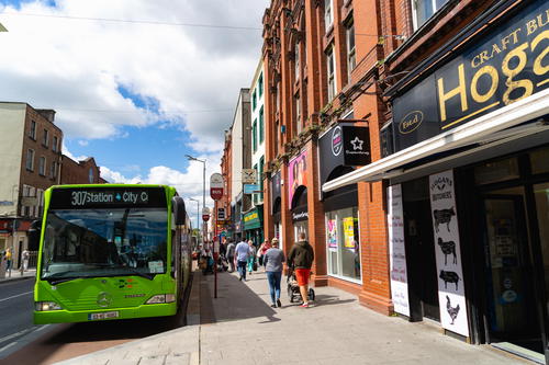 A green double decker bus traveling along the Wild Atlantic Way in Ireland.