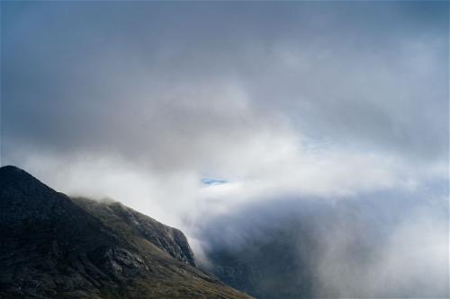A cloud-covered mountain along the Wild Atlantic Way in Ireland under a blue sky.