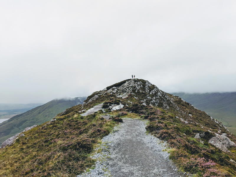 A person is standing on top of a mountain in Ireland.