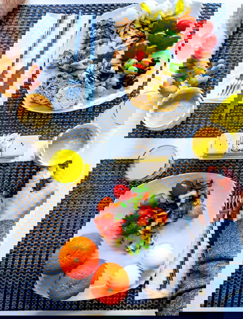 A table with Israeli cuisine featuring a plate of food and a cup of orange juice.