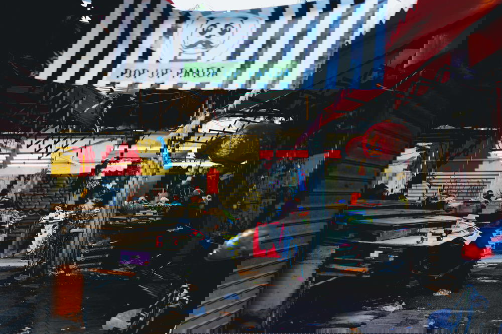 A market in Israel with a black and white banner hanging from the ceiling.