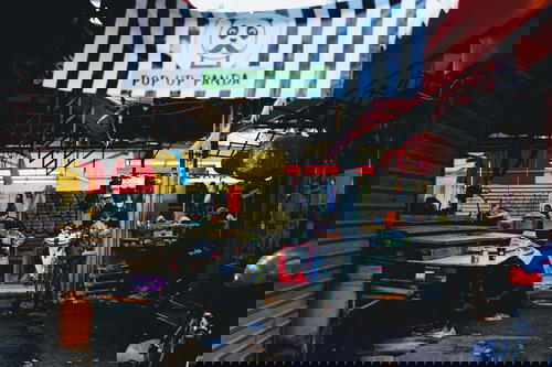 A market in Israel with a black and white banner hanging from the ceiling.