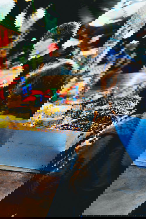 A man and a woman standing at a food stand in Israel.