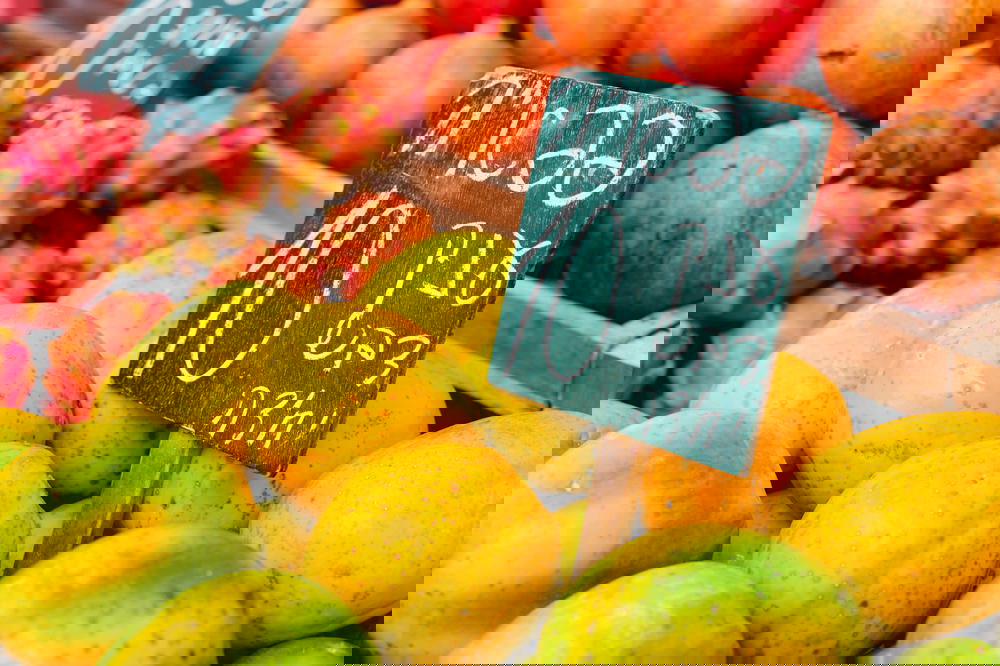 Blackboard sign in Hebrew writing placed among mangos and dragon fruits in an Israeli market