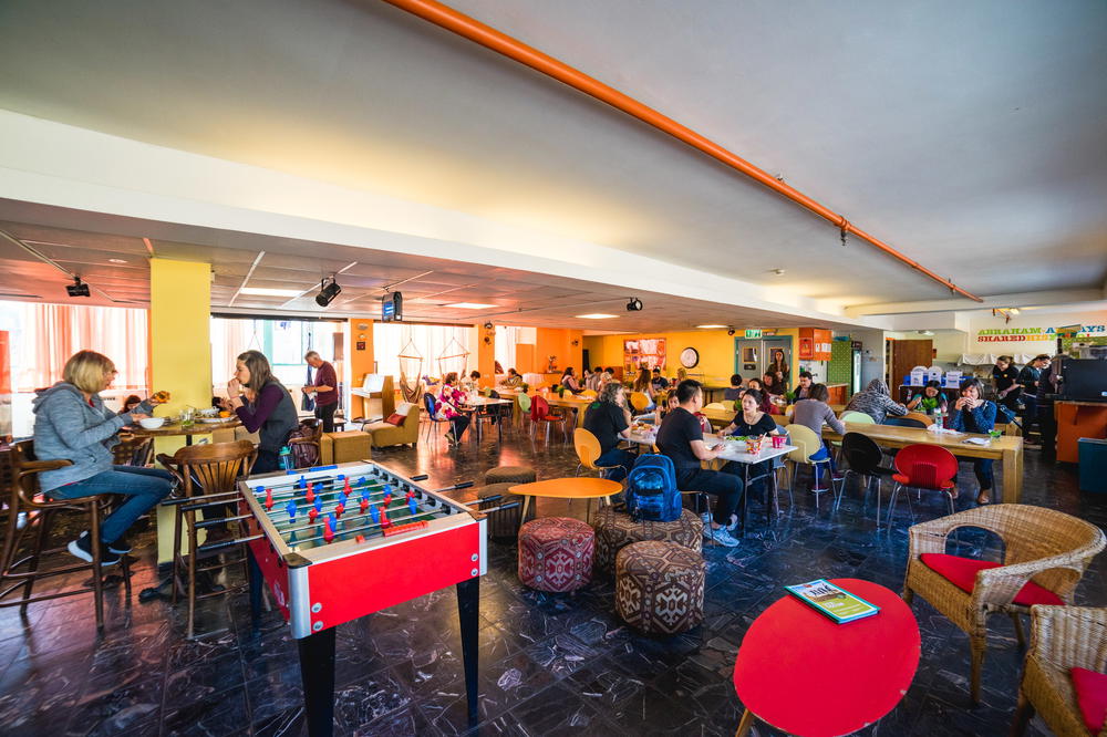 A group of people playing foosball in an Israeli cafe.