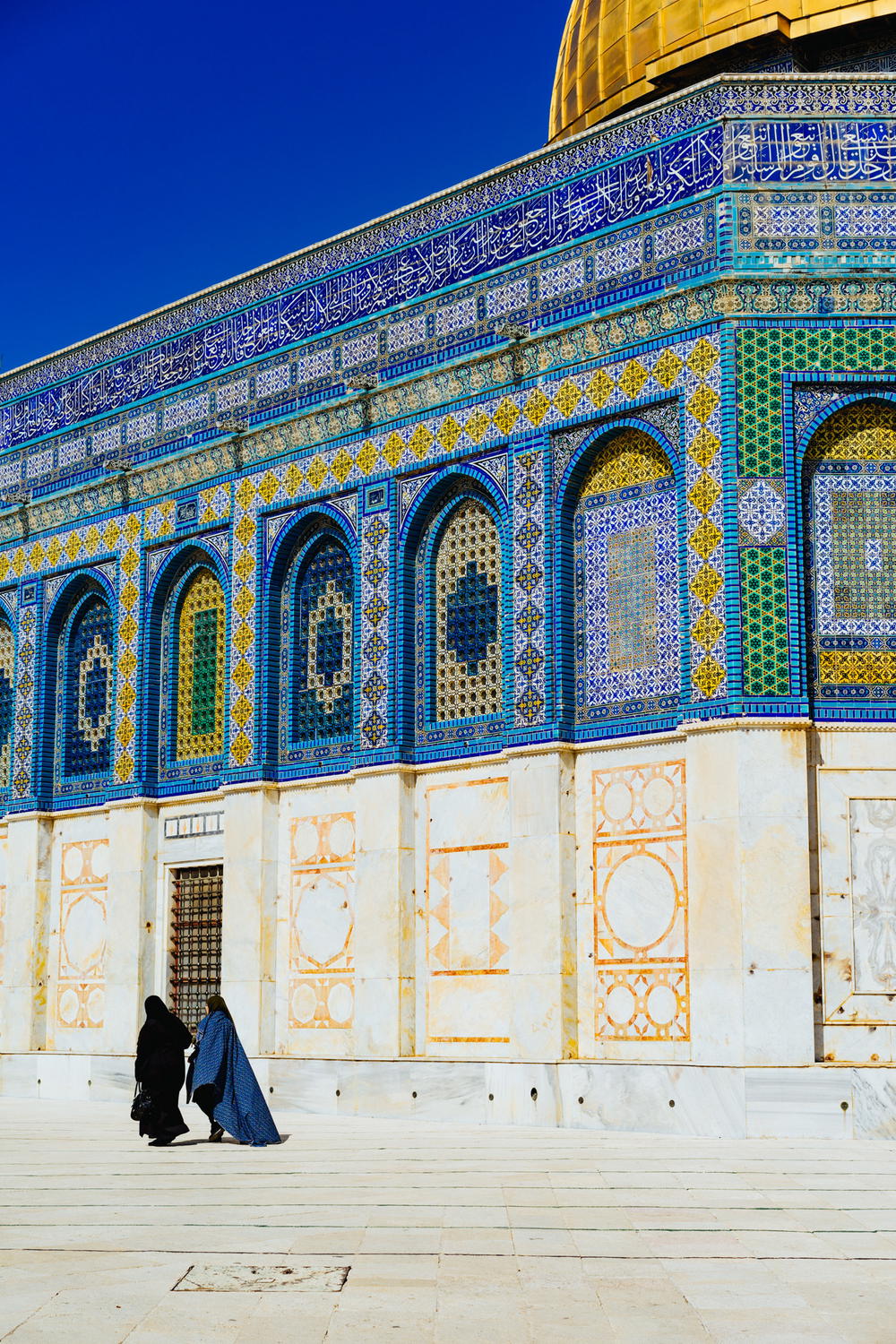 Women wearing hijabs walking in the sun at Dome of the Rock at the Temple Mount in Jerusalem Israel