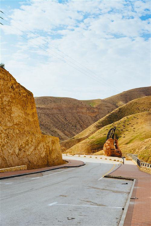 Winding highway road through yellow desert hills in Israel