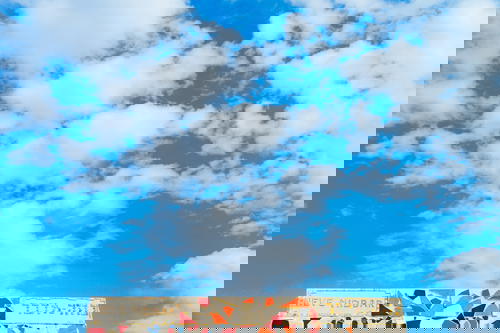 White stone and red and gray mosaic design against a blue sky