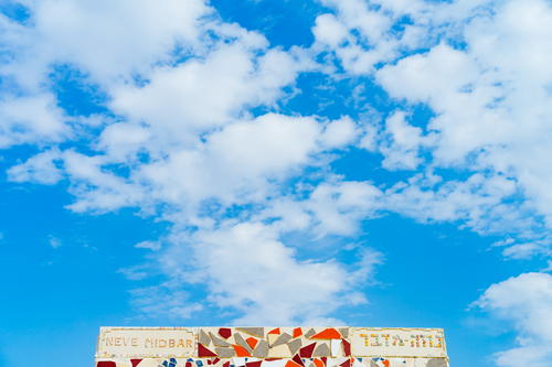 White stone and red and gray mosaic design against a blue sky