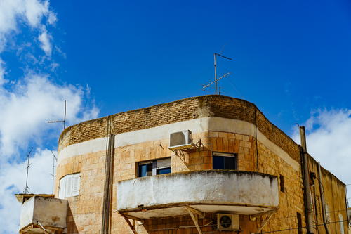 Retro Bahaus architecture in tan and white stone against a blue sky