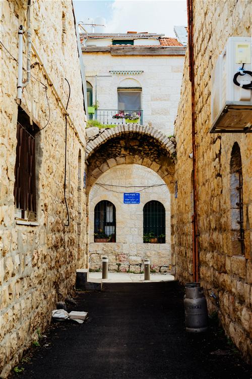 White Jerusalem stone arches in a narrow alleyway