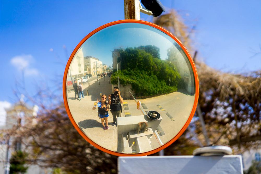 Becca and Dan taking a reflection selfie in a traffic mirror in Jaffa, Israel