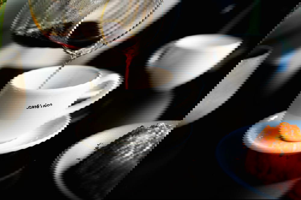 Mexican coffee being poured into a cup on a table.